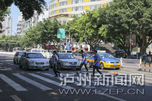 四川警察學(xué)院前的斑馬線沒有紅綠燈，但過往車輛見到有行人過斑馬線都會禮讓行人